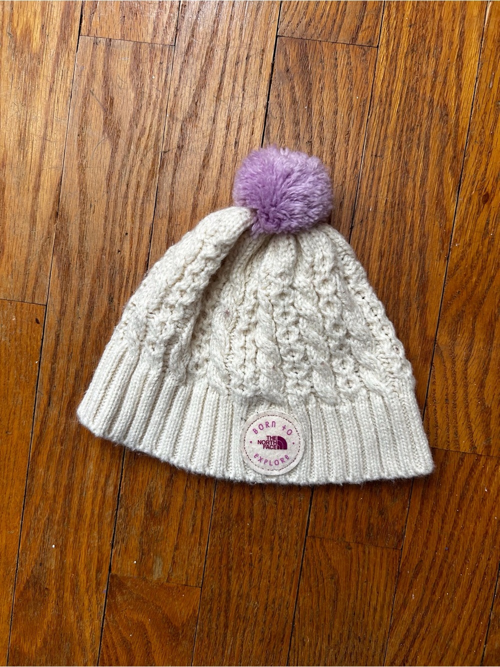 The North Face Baby Cream Cable Knit Beanie with Purple Pom